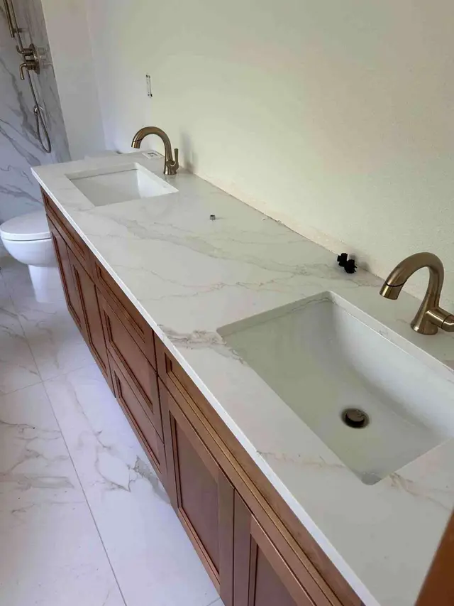 Bathroom vanity with brushed gold faucets and marble countertop installed in Happy Valley OR – Efficiency Plumbing