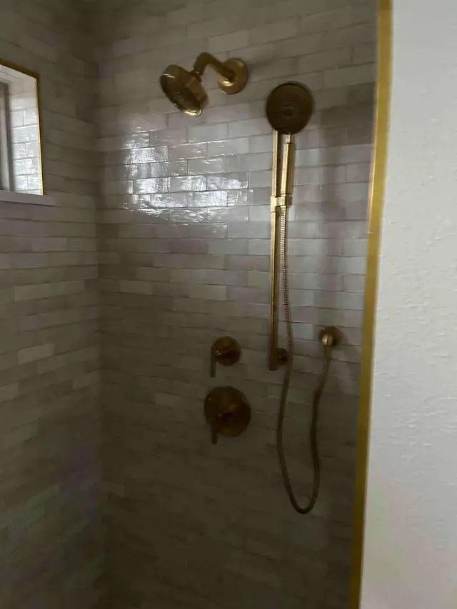 Dual shower head system with slide bar and gold fixtures on subway tile in Sandy OR – Efficiency Plumbing