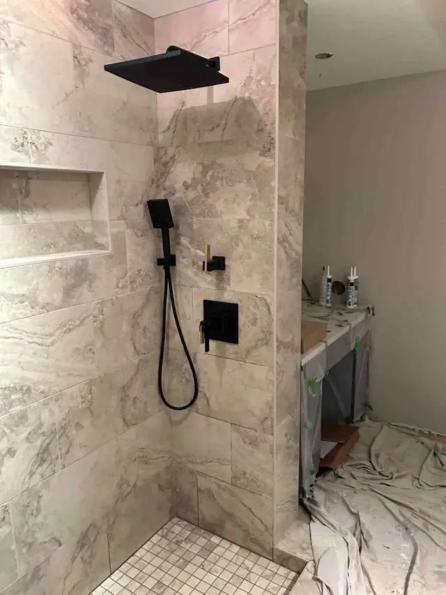 Custom marble tile shower with matte black rain head and built-in niche in Estacada OR – Efficiency Plumbing