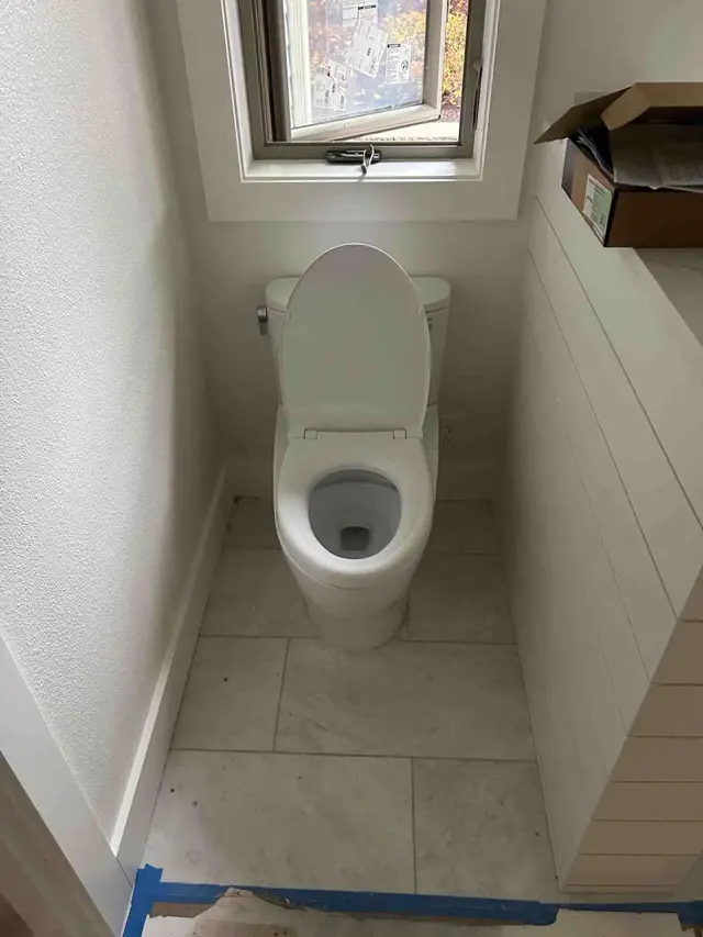 Modern toilet installation with marble wall tile and window in Happy Valley OR – Efficiency Plumbing